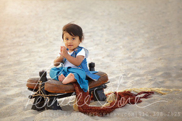 One year old boy on the beach, camel saddle